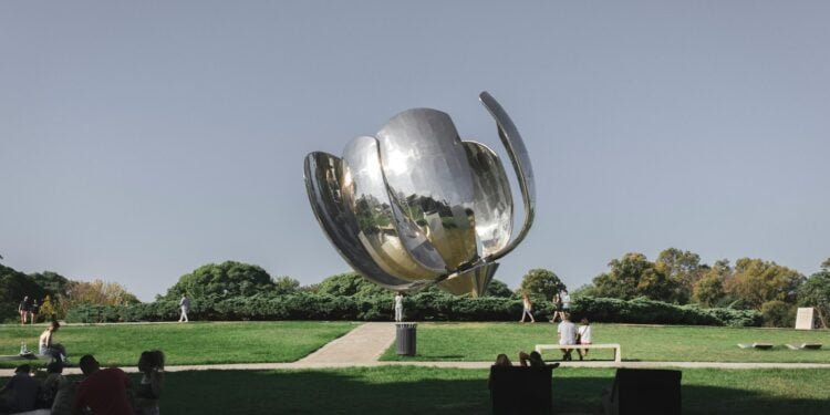 a large metal object sitting on top of a lush green field