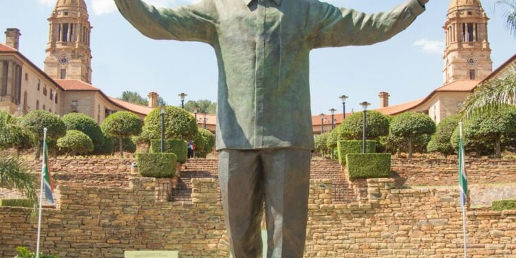 a statue of a man standing in front of a building