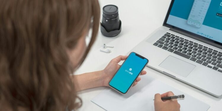 woman holding smartphone while writting