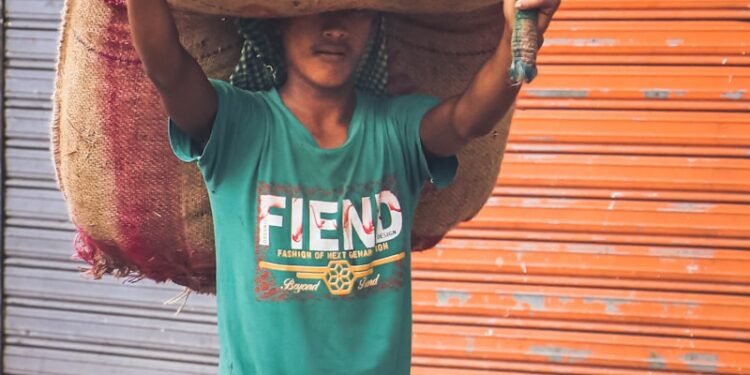 a man carrying a large sack on his head